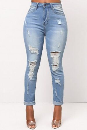 A woman wearing ripped jeans and high heels.