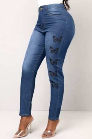 A woman wearing jeans with butterflies on them.